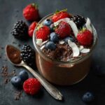 Chocolate chia seed pudding in a glass jar with fresh berries