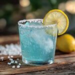 Final result of the blue salt trick recipe in a clear glass with lemon